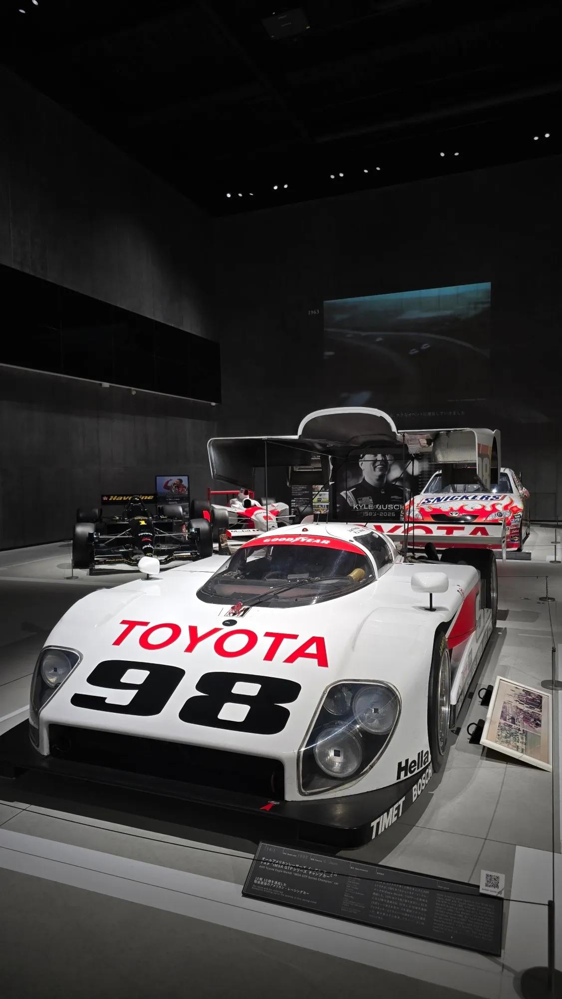 Prototype de course Toyota GTP blanc exposé dans une salle sombre du musée